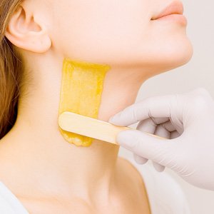 Imagen de mujer a la que se le hace una depilación de cuello con cera