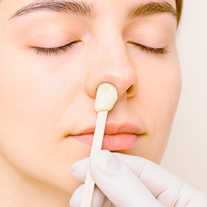Imagen de mujer a la que se le hace una depilación nasal con cera