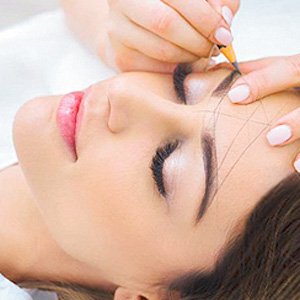 Mujer a la que se le hace un diseño de cejas