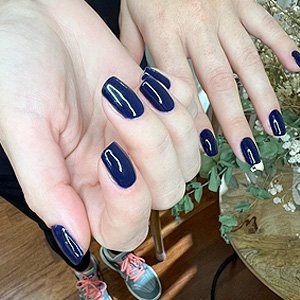 Imagen de manos femeninas luciendo una manicura con esmaltado semipermanente más nivelación
