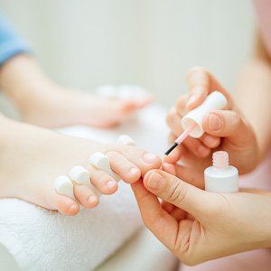 Imagen de pies infantiles a los que se les hace la pedicura