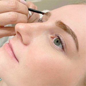 Imagen de mujer a la que se le aplica un tinte de cejas