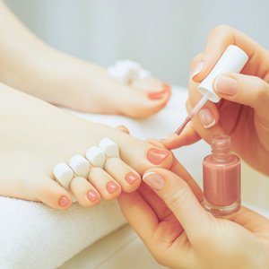 Imagen de pies a los que se les hace una pedicura express con esmaltado tradicional